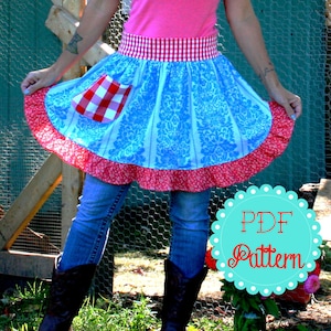 May include: A blue and red gingham print apron with a white damask pattern. The apron has a ruffled hem and a red and white gingham waistband. The apron is worn by a person wearing blue jeans and cowboy boots. The text "PDF Pattern" is on a teal circle with white polka dots.