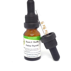 May include: A brown glass bottle with a black dropper cap and a green label that reads "Herbs & homeo's Smart & Healthy Feline Thyroid". The label also includes instructions for use and ingredients, including Anacardium Iodine, Areca Barta, 90% distilled water, 10% grain alcohol, and the address 503 N. 8th St. Rochelle, IL 61068.