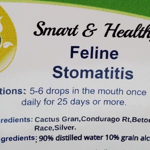 May include: A white label with green and yellow leaf designs. The text "Smart & Healthy Feline Stomatitis" is printed in black. Directions for use are listed: "5-6 drops in the mouth once daily for 25 days or more." The active ingredients are listed: "Cactus Gran, Condurago Rt, Betonica, Aralia Race, Silver." The inactive ingredients are listed: "90% distilled water 10% grain alcohol."