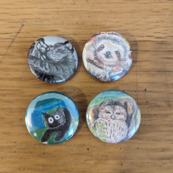 Marriott Sketches Pins, Badges and Wooden Badges | Original Artwork including: Bonnie Cat, Sloth Boy, Cartoon Bonnie Cat and Optimistic Owl