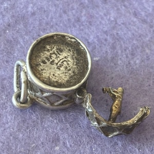 Può includere: Ciondolo in argento di un tamburo con un batterista che suona, sul retro del ciondolo è incisa la scritta "925 ITALY".