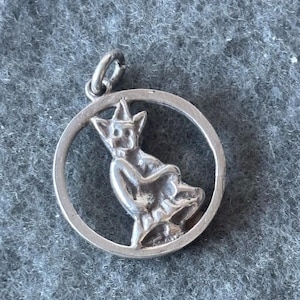 May include: Silver charm featuring a detailed, three-dimensional depiction of a gargoyle sitting inside a circular frame.