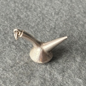 May include: A silver charm in the shape of a traditional Spanish wine pitcher, known as a porrón, with a loop for attaching to a bracelet or necklace.
