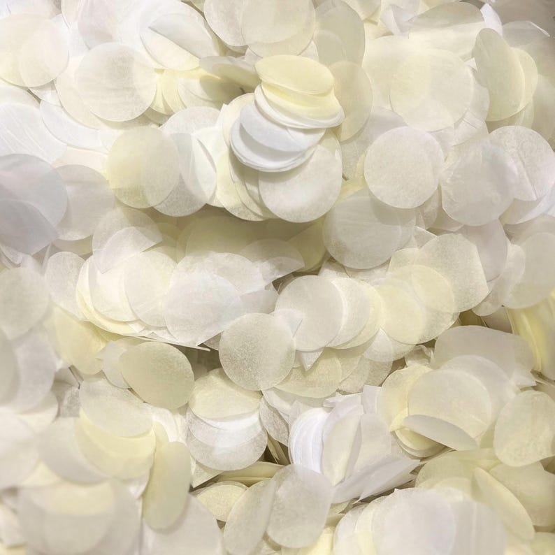 May include: A large pile of white and cream paper confetti circles. The confetti is made of thin, delicate paper and is perfect for adding a touch of elegance to any celebration.