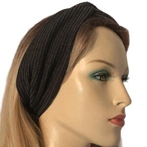 May include: A black ribbed turban headband. The headband is twisted and knotted at the top.