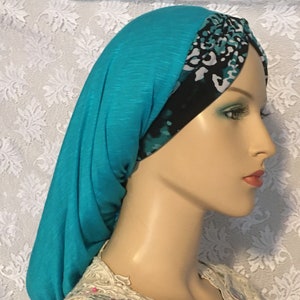 Peut inclure: Couvre-chef en tissu bleu turquoise avec une bordure à motifs noirs et blancs. La bordure présente un motif léopard.