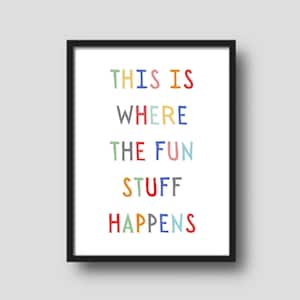 May include: A black framed print with the text "THIS IS WHERE THE FUN STUFF HAPPENS" in colorful letters.