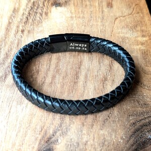 Personalized Black Leather Bracelet for Men, Engraved Magnetic Clasp | Custom Gift for Husband, Boyfriend or Dad, Custom Father's Day name. Handcrafted from black braided leather with an engraved black clasp, this personalized bracelet is rugged, refined, and ridiculously handsome. Black braided leather bracelet with a engraved black metal plate that reads “Always 06.29.24.” Displayed on a rustic wooden surface, this personalized accessory makes a meaningful anniversary or wedding gift for him