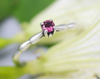 Dainty silver band with faceted round pink tourmaline gemstone in prongs setting