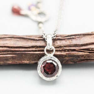 Round faceted red garnet pendant necklace in silver bezel setting with sterling silver chain