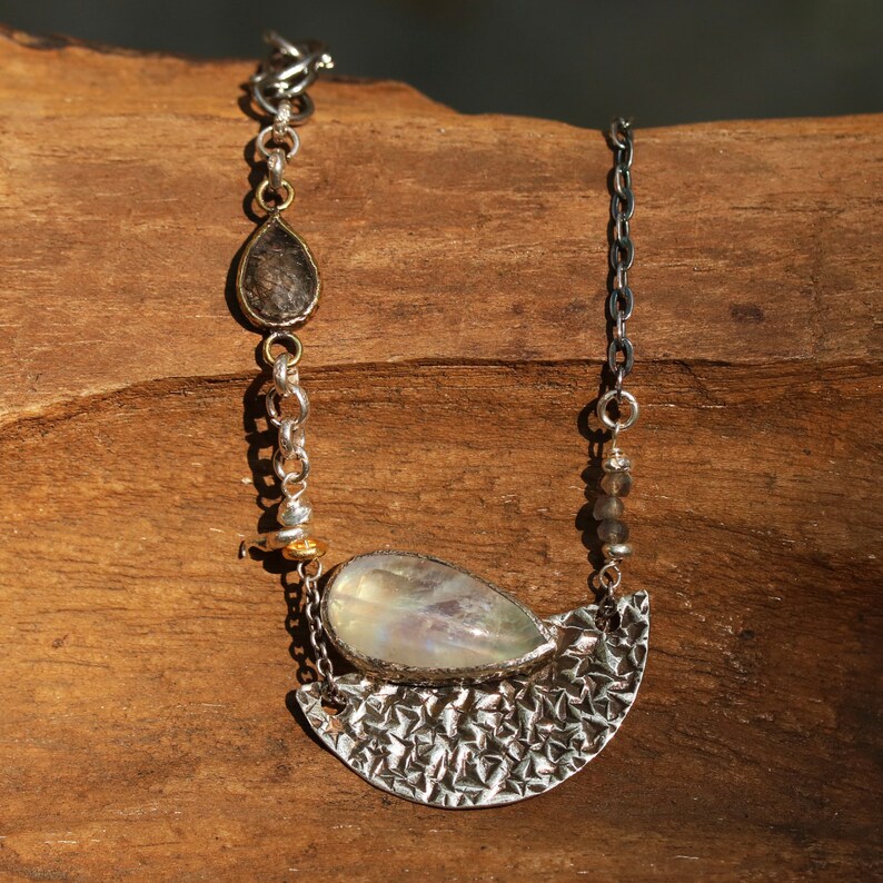 Moonstone pendant necklace in silver bezel setting and silver textured fan with black rutilated quartz on the side and oxidized silver chain
