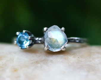 Faceted moonstone ring in silver bezel setting and blue topaz on the side with sterling silver band