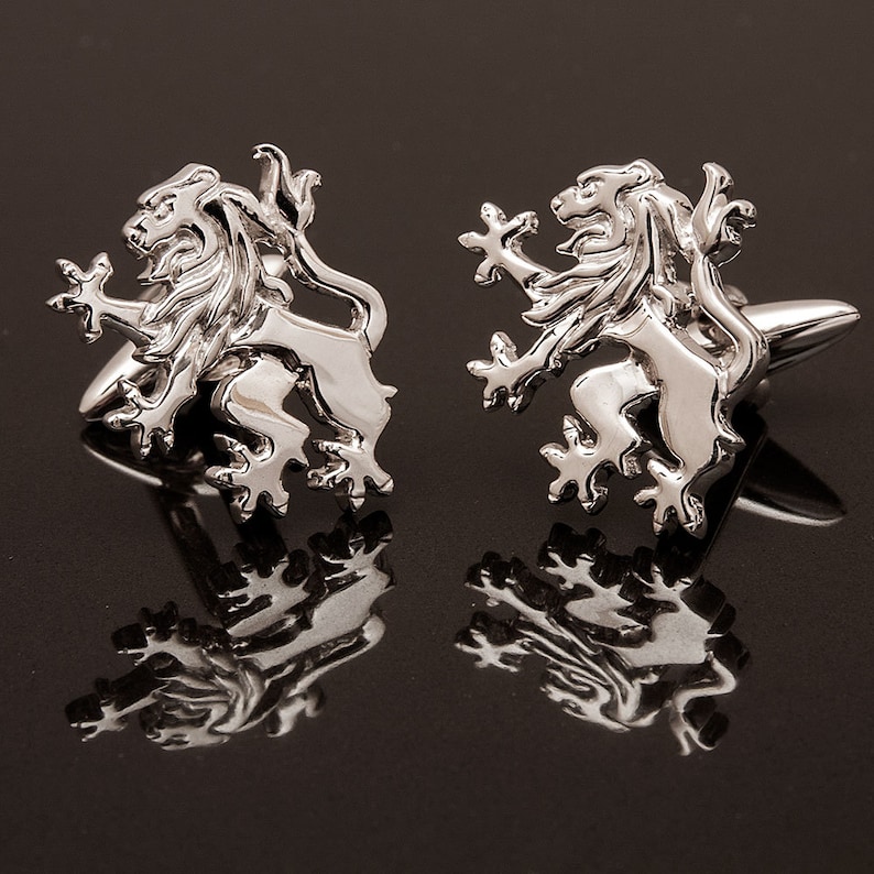 May include: A pair of silver cufflinks featuring a lion design. The lions are facing forward with their paws raised.