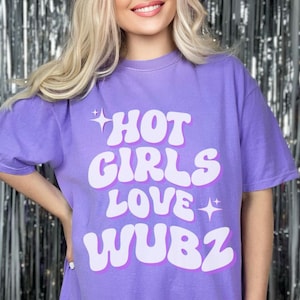 May include: Purple t-shirt with a white graphic that says "HOT GIRLS LOVE WUBZ" in a retro font.