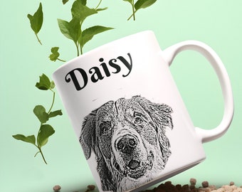 May include: White ceramic mug with a black and white illustration of a dog's face and the name "Daisy" printed on the front. The mug is tipped over and spilling brown dog food.