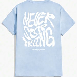 May include: Light blue t-shirt with a white graphic print that says "NEVER STOP TRYING" and "Don't stop your grind".