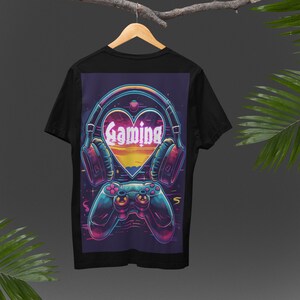 May include: Black t-shirt with a graphic print of a heart with the word "Gaming" inside, headphones, and a video game controller. The heart is surrounded by a colorful, pixelated design.