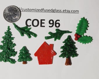 May include: A collection of fused glass holiday-themed shapes including green pine trees, a red house, green holly leaves with red berries, and green branches. A US quarter is shown for scale. Text reads customizedfusedglass.etsy.com and COE 96.