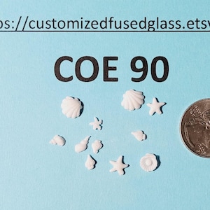 May include: A light blue background with white seashell and starfish shaped glass pieces. A dime is next to the glass pieces for size comparison. The text "COE 90" is in the center of the image, and the website address is at the top.