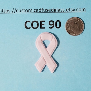 Könnte beinhalten: Ein hellrosa Band, ein Symbol des Bewusstseins, wird auf hellblauem Hintergrund gezeigt. Eine Münze liegt neben dem Band. Der Text "COE 90" befindet sich über dem Band. Die Etsy-Shop-URL steht oben.