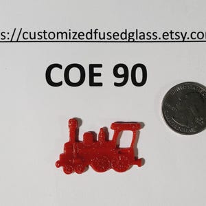 May include: A small, red glass train figurine next to a US quarter coin. The text "COE 90" is above the train. The Etsy shop URL is at the top. The train is a detailed, miniature representation of a classic locomotive.