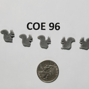 May include: Five gray plastic squirrel figurines, each about the size of a US quarter, arranged in a row. The text "COE 96" is printed above the figurines.
