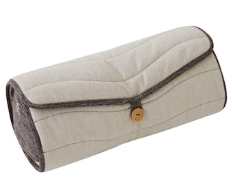May include: A beige and brown cylindrical pillow with a button closure. The pillow has a quilted design and a brown trim.
