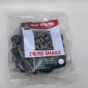 May include: A transparent bag containing dried snails. The label reads "Moli Organic Farm & Foods" and "Dried Snails". The label also includes contact details and a picture of snails.