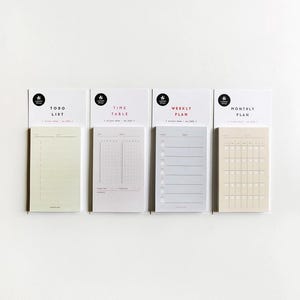 May include: Four sticky note pads for planning, labelled "Todo List", "Time Table", "Weekly Plan", and "Monthly Plan". Each pad has a different layout, with lines, grids, and a calendar format. The pads are in shades of beige, grey, and white. The pads are attached to white backing cards.