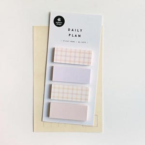 May include: A set of sticky notes with a "Daily Plan" header. The notes are in pastel colors, with two featuring a plaid pattern. The design includes the text "Sticky Memo No. 1979" and a small logo.