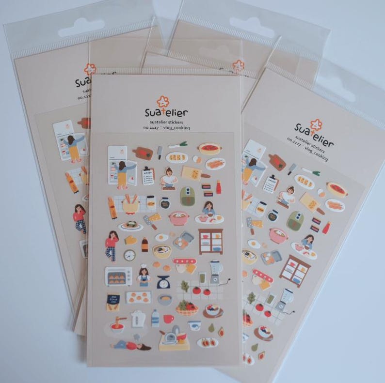 May include: Several sticker sheets featuring cooking-themed illustrations. Each sheet displays various kitchen items, food, and people cooking. The text "Sua atelier" and "vlog_cooking" are visible on the packaging.