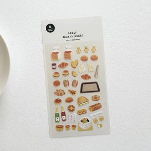 Op de afbeelding: Een vel "Daily Deco Stickers" met illustraties met een bakkerijthema. De stickers bevatten broden, croissants, gebakjes, taarten en flessen. De tekst "Daily Deco Stickers" en "5377: old bakery" staat bovenaan het vel.