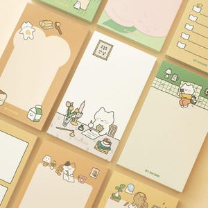 Può includere: Un set di blocchi di note adesive colorati con illustrazioni carine di gatti e altri animali. Le note sono perfette per aggiungere un tocco di fantasia alla tua scrivania o al tuo planner. Ogni blocco ha un design diverso e include il testo "BY.NACOO".