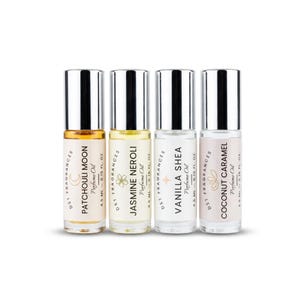 May include: Four clear glass rollerball perfume bottles with silver caps, each containing 4.5 ml of oil. Labels read DST Fragrances, Perfume Oil, and 0.15 fl. oz., featuring the scents Patchouli Moon, Jasmine Neroli, Vanilla Shea, and Coconut Caramel.