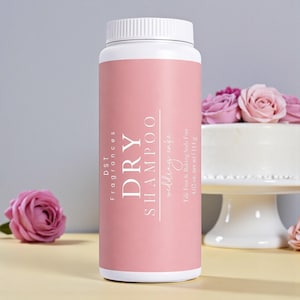 May include: A pink and white dry shampoo bottle with the text "DRY SHAMPOO" and "wedding cafe". The bottle is 4.02 oz. net wt / 114 g. A cake and roses are in the background.