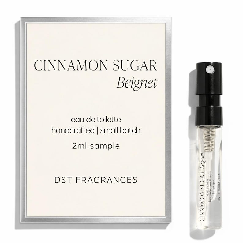 May include: A 2ml sample of Cinnamon Sugar Beignet eau de toilette by DST Fragrances. The product is presented with a rectangular card featuring the text Cinnamon Sugar Beignet, eau de toilette, handcrafted | small batch, 2ml sample, DST FRAGRANCES.