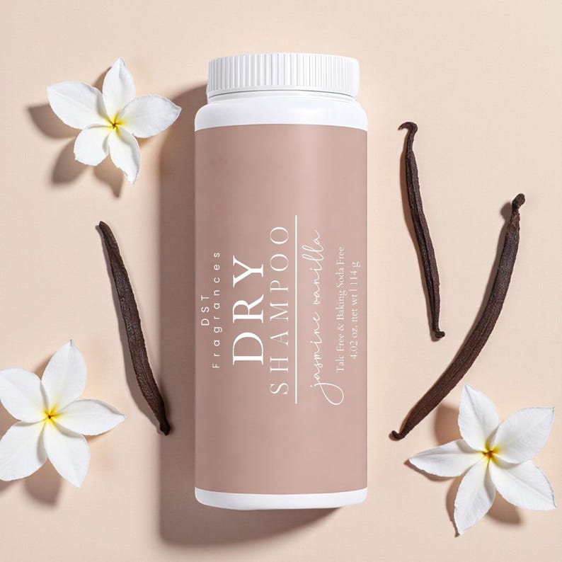 May include: A white and tan dry shampoo bottle with the text "DRY SHAMPOO jasmine vanilla". The bottle is surrounded by white flowers and dark brown vanilla beans. The bottle contains 4.02 oz. of product.