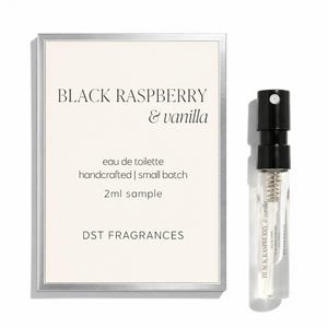 May include: A 2ml sample spray vial of Black Raspberry & vanilla eau de toilette by DST FRAGRANCES, accompanied by a rectangular product card with a silver border featuring the scent name, product details, and brand name in black text.