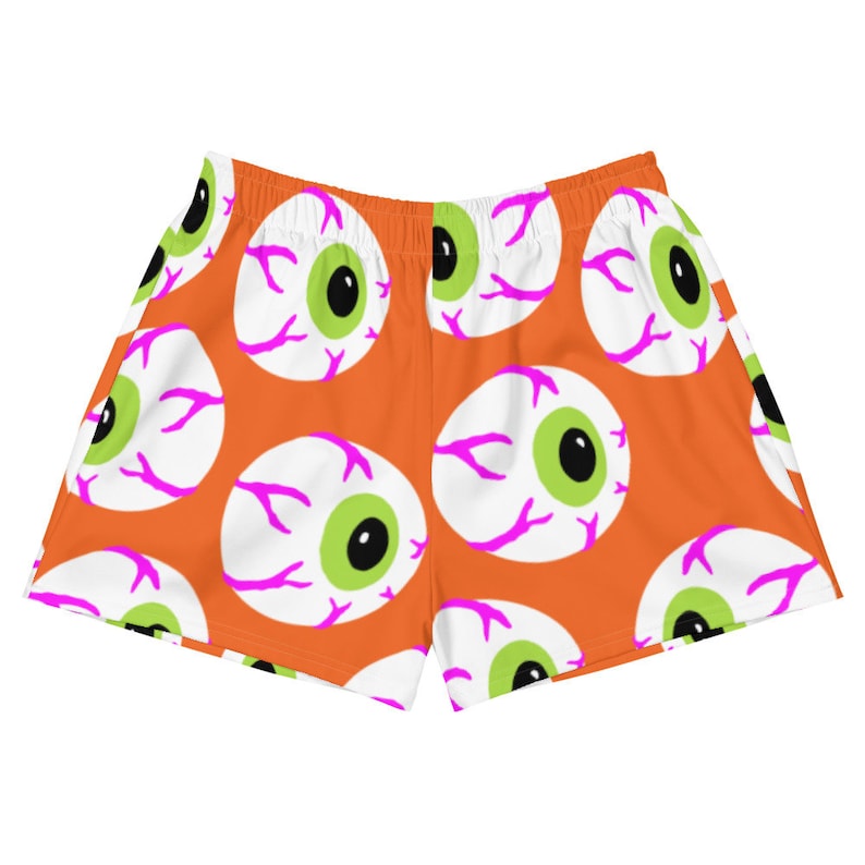 May include: Orange athletic shorts with a repeating pattern of white eyeballs with green pupils and pink veins.
