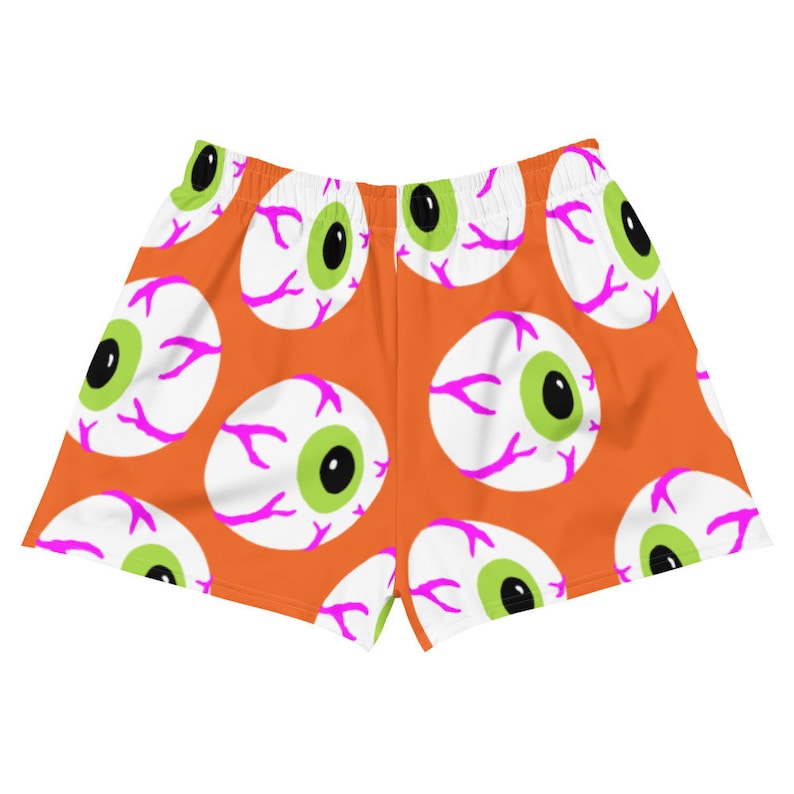 May include: Orange athletic shorts with a repeating pattern of white eyeballs with pink veins and green pupils.