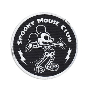 Op de afbeelding: Zwarte en witte geborduurde patch met een skelet Mickey Mouse-ontwerp. De patch heeft de tekst "Spooky Mouse Club" rond de rand.
