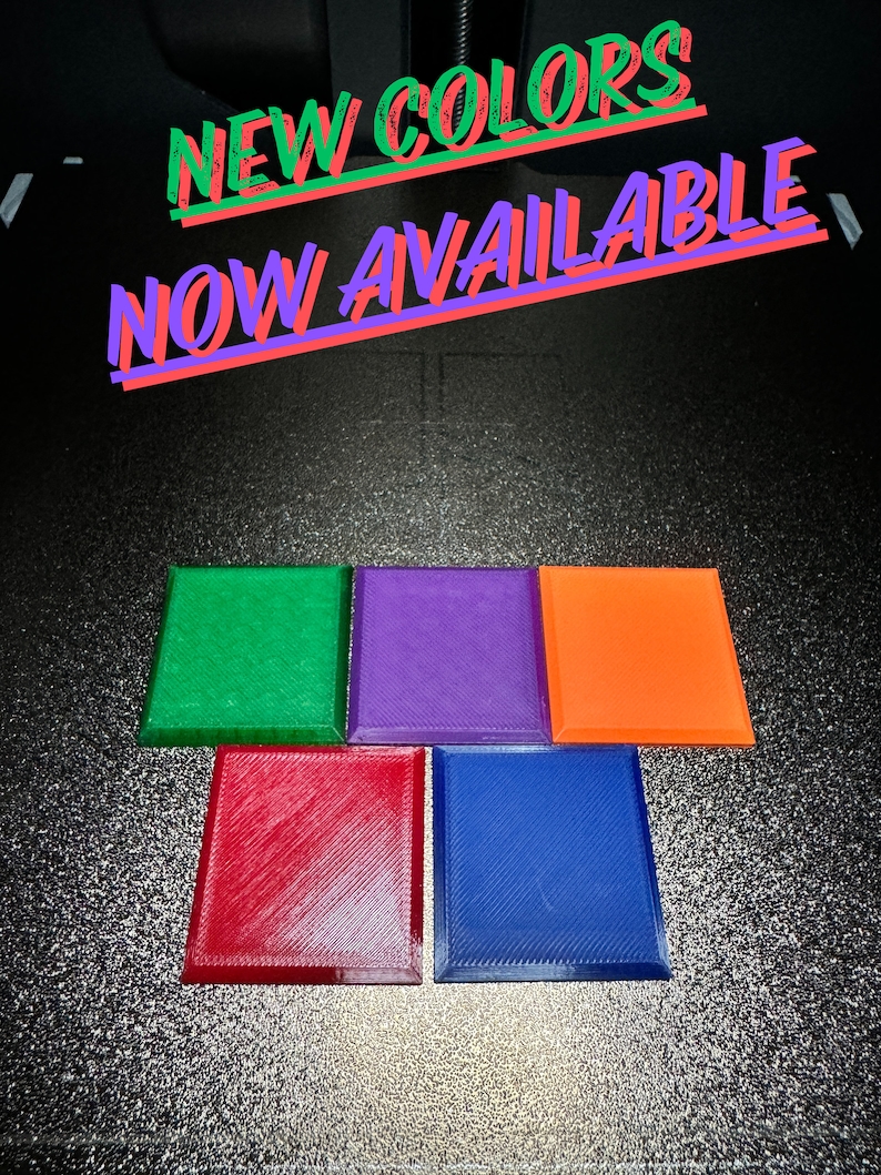 Puede incluir: Cinco posavasos cuadrados en diferentes colores: verde, morado, naranja, rojo y azul. Los posavasos est&aacute;n hechos de un material texturizado y tienen un borde ligeramente elevado. El texto "NEW COLORS NOW AVAILABLE" est&aacute; escrito en letras rojas y verdes sobre un fondo negro.