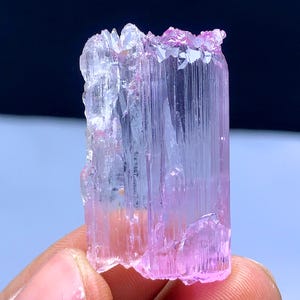Peut inclure: Un cristal rose et transparent avec des stries. Le cristal est translucide et a une l&eacute;g&egrave;re teinte rose. C'est un sp&eacute;cimen min&eacute;ral naturel.