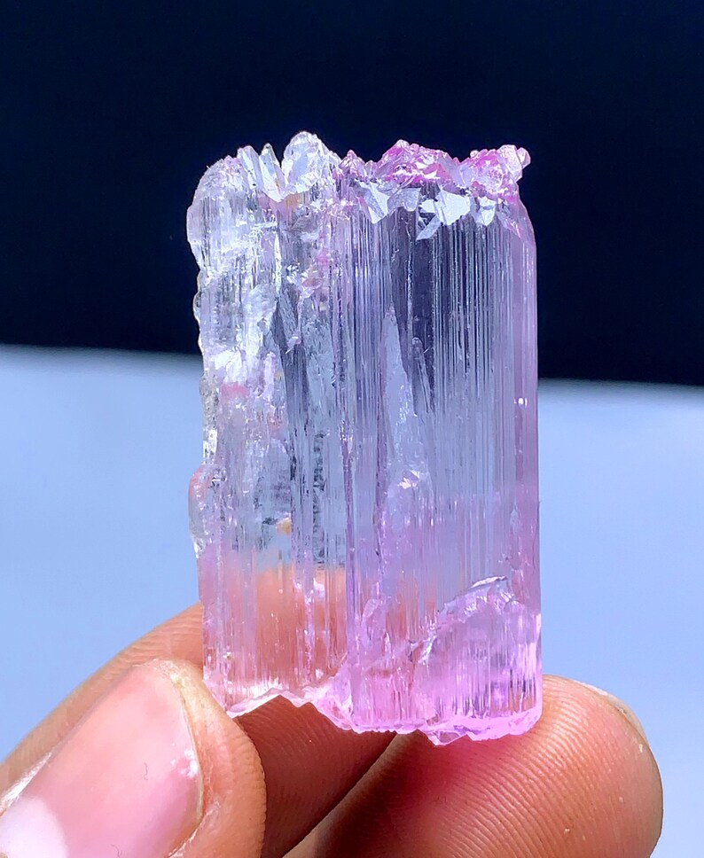 Peut inclure: Un cristal rose et transparent avec des stries. Le cristal est translucide et a une l&eacute;g&egrave;re teinte rose. C'est un sp&eacute;cimen min&eacute;ral naturel.
