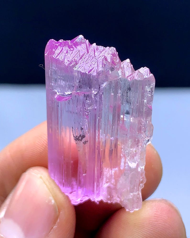 Peut inclure: Un cristal rose et transparent avec une texture stri&eacute;e. Le cristal est translucide et a une l&eacute;g&egrave;re teinte rose.