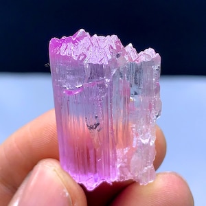 Peut inclure: Un cristal rose et transparent avec une texture stri&eacute;e. Le cristal est translucide et a une l&eacute;g&egrave;re teinte rose. C'est un sp&eacute;cimen min&eacute;ral naturel.