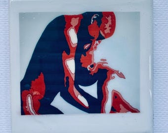 Pode incluir: Uma pintura abstrata em vermelho e azul que representa duas figuras se abraçando. O título "The Kiss" está escrito abaixo da imagem.