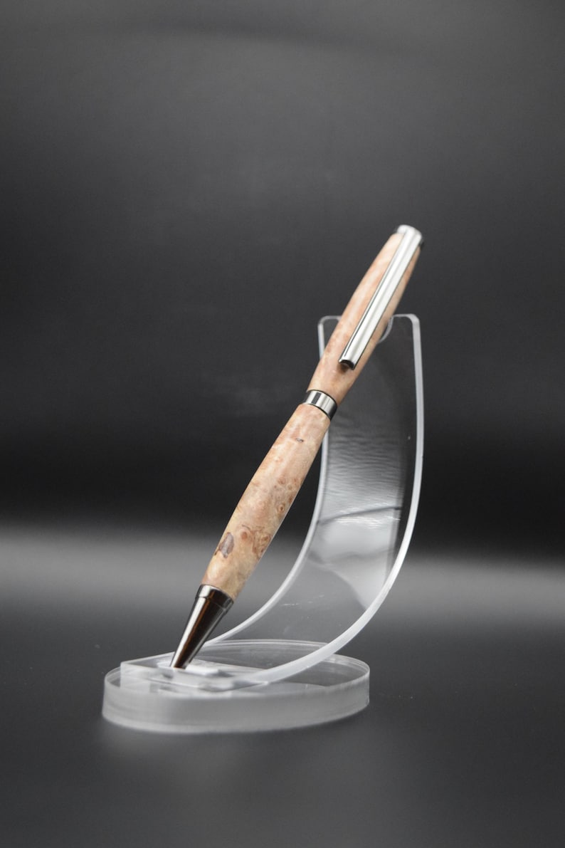 Op de afbeelding: Een houten pen met een zilveren rand en een bruin burl-houten patroon. De pen wordt getoond op een transparante kunststof standaard.