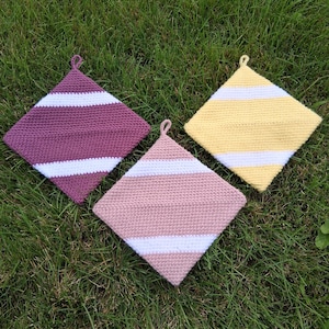 May include: Three square crochet potholders with small hanging loops at the top corner. Each potholder features a striped pattern of white alternating with solid colors: one is deep purple, one is pale yellow, and one is a muted dusty rose pink.