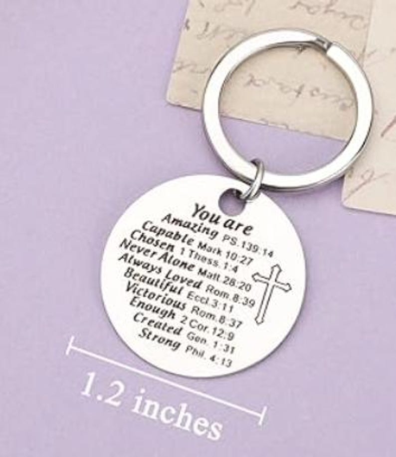 May include: Silver keychain with a round charm that reads "You are Amazing" and includes a list of positive affirmations and bible verses. The charm is 1.2 inches in diameter.
